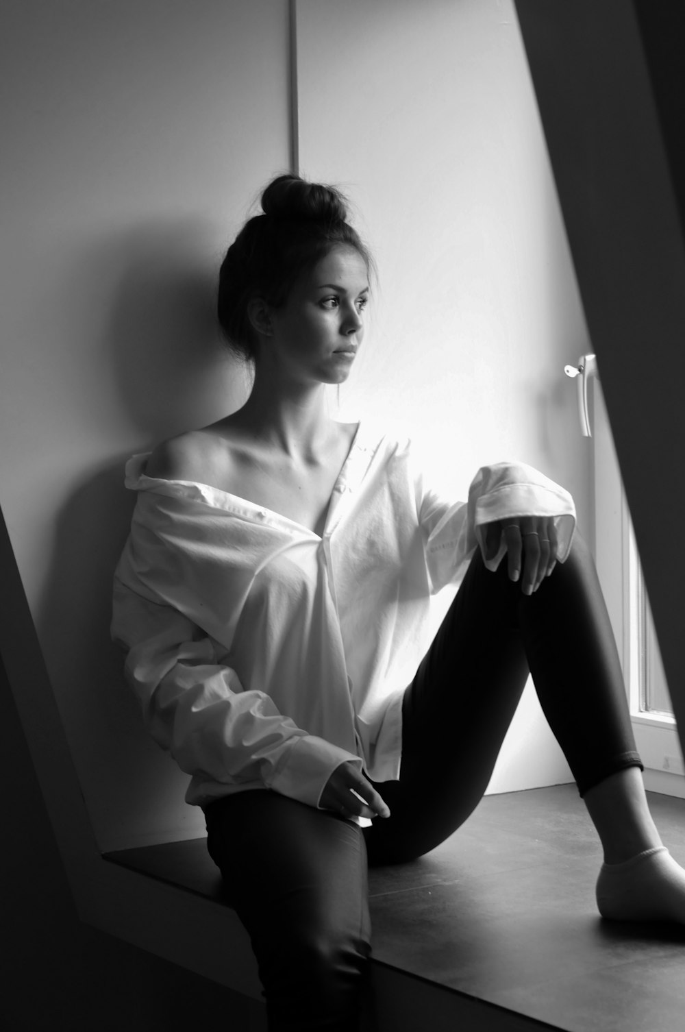 woman in white long sleeve shirt and black pants sitting on floor