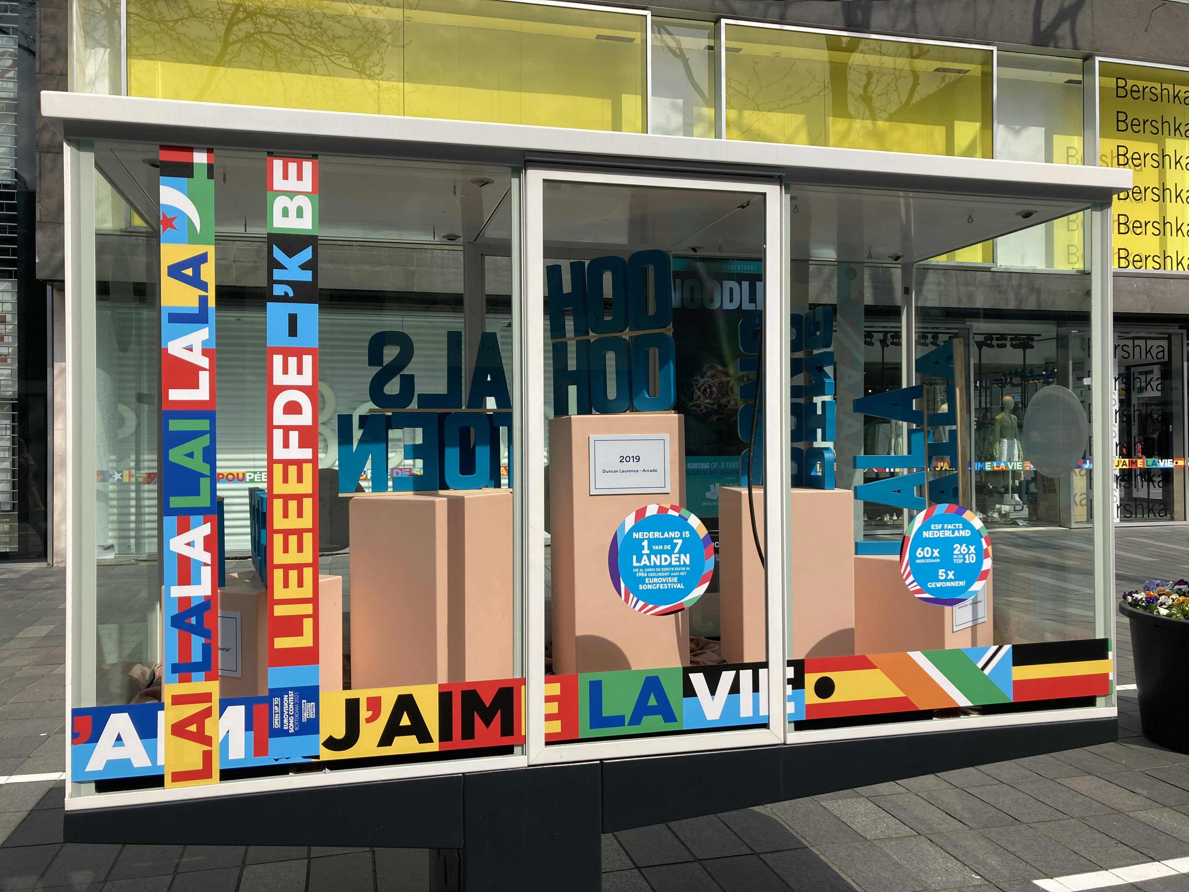 Bright shop window with bold colorful lettering graphics in daylight