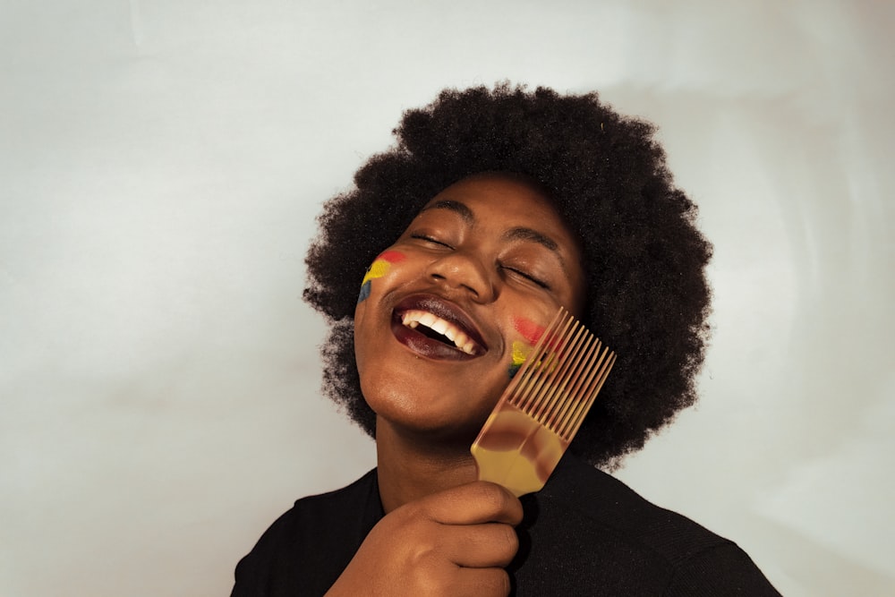 woman in black shirt holding brown wooden stick