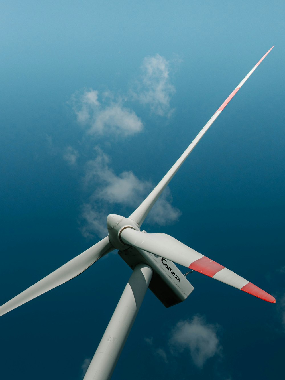 white and red wind turbine under blue sky during daytime