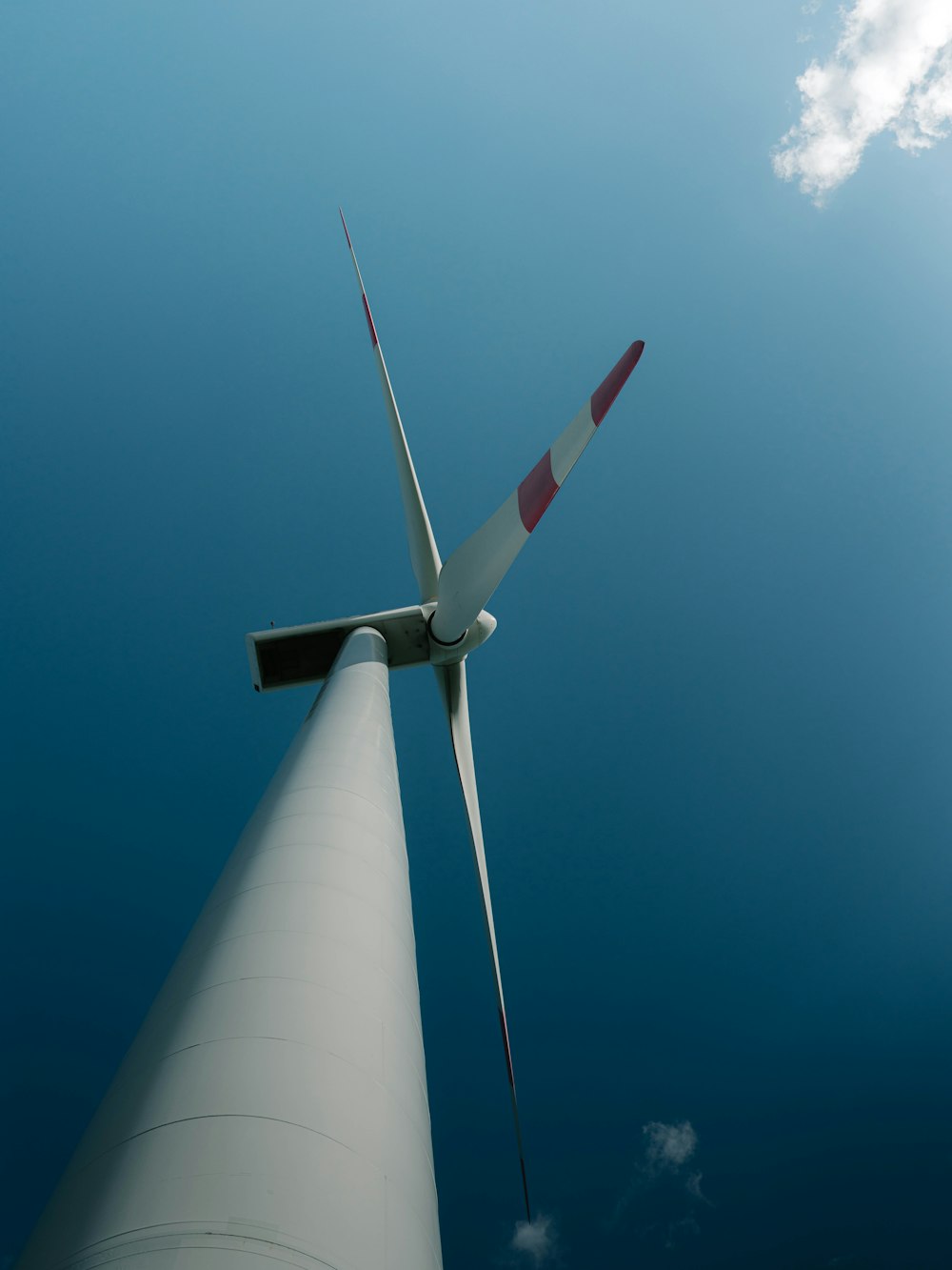 turbina eólica blanca y roja bajo el cielo azul durante el día