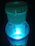 A close-up of a Mind Effect bottle with gold, sea blue, and purple accents glowing softly.