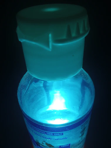 Close-up of a sleek white bottle with medical blue label glowing softly against a clean white background.