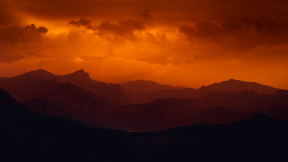 silhouette of mountains under cloudy sky during daytime