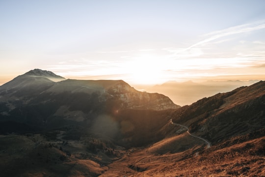 Sunrise over the rugged Atlas Mountains with a winding trail below.