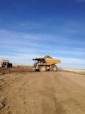brown utility truck on brown sand under blue sky during daytime