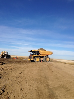 brown utility truck on brown sand under blue sky during daytime