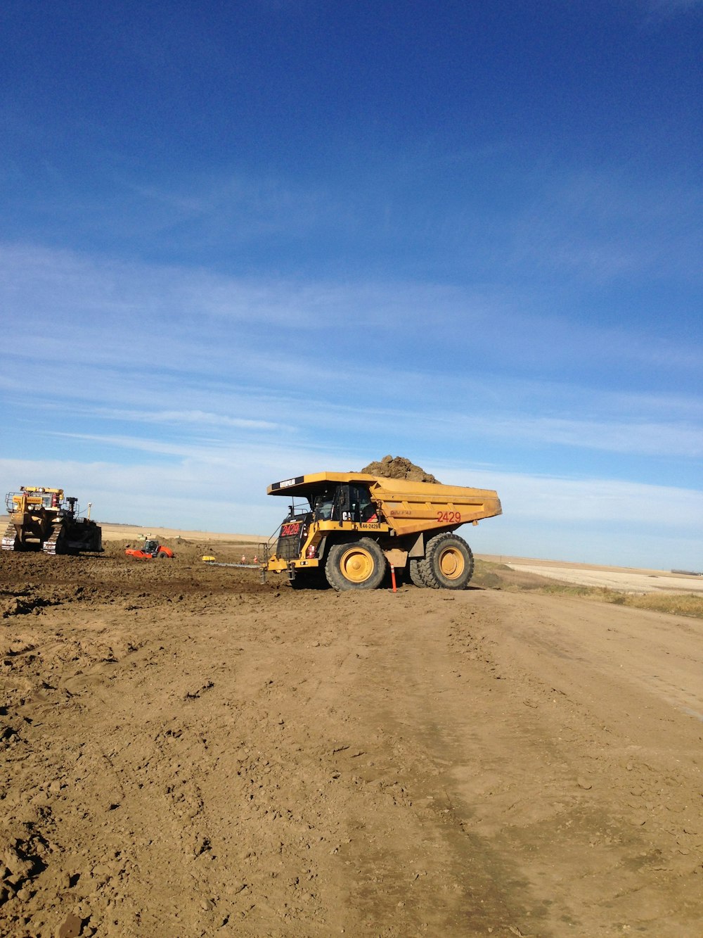 brown utility truck on brown sand under blue sky during daytime