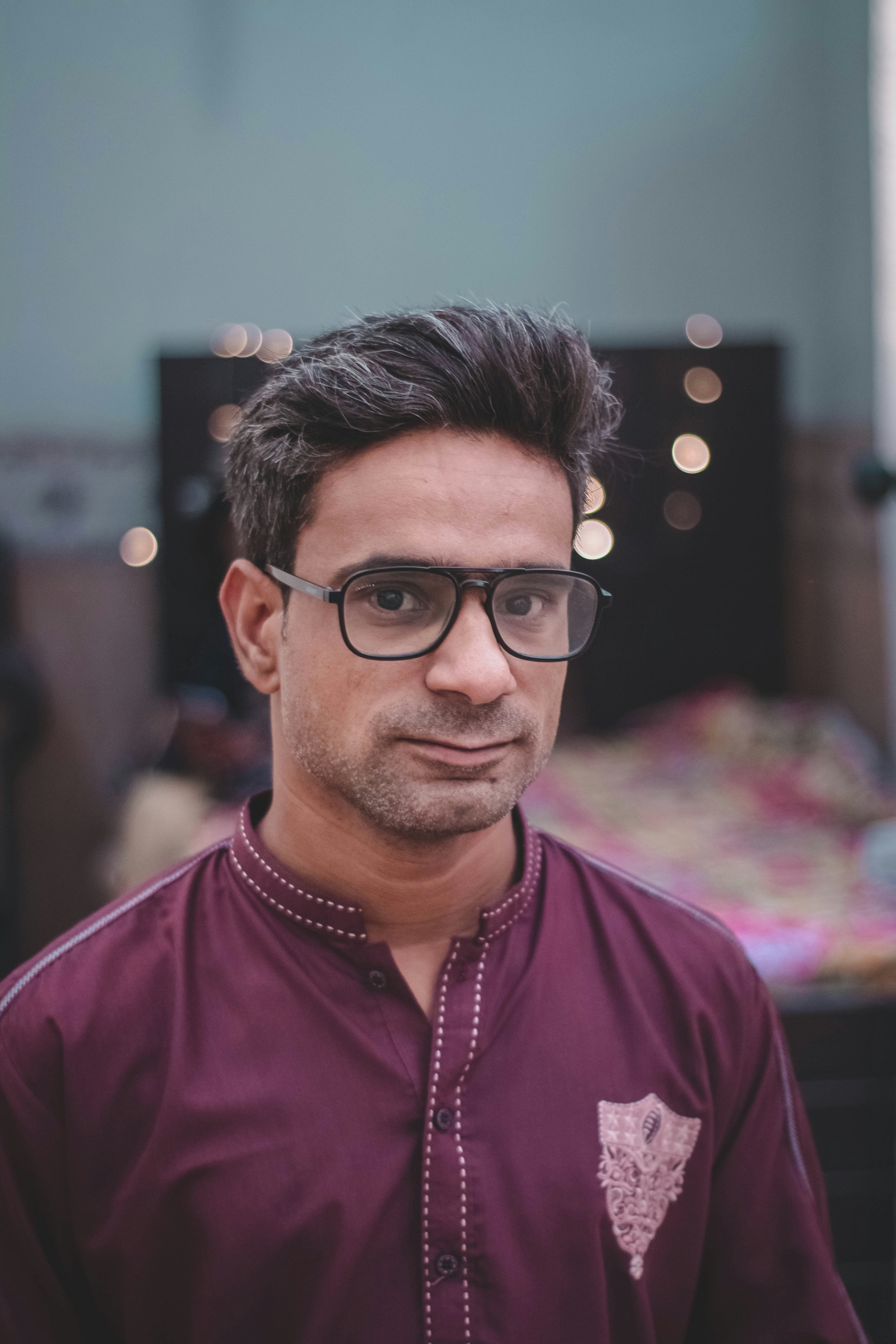 man in purple dress shirt wearing black framed eyeglasses