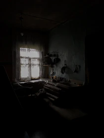 Before image of a cluttered kitchen with outdated cabinets and dull lighting.