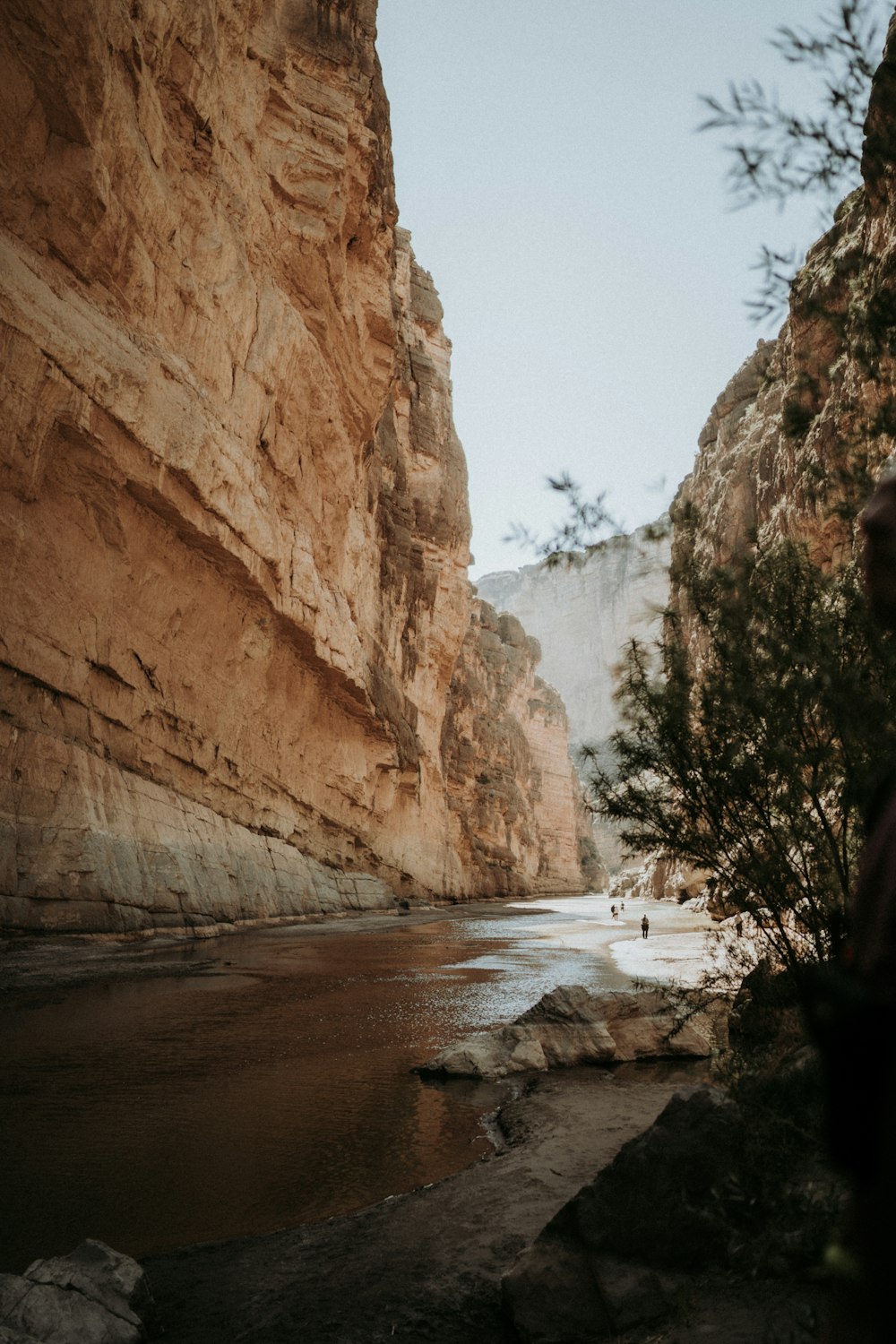 brown rocky mountain near body of water during daytime