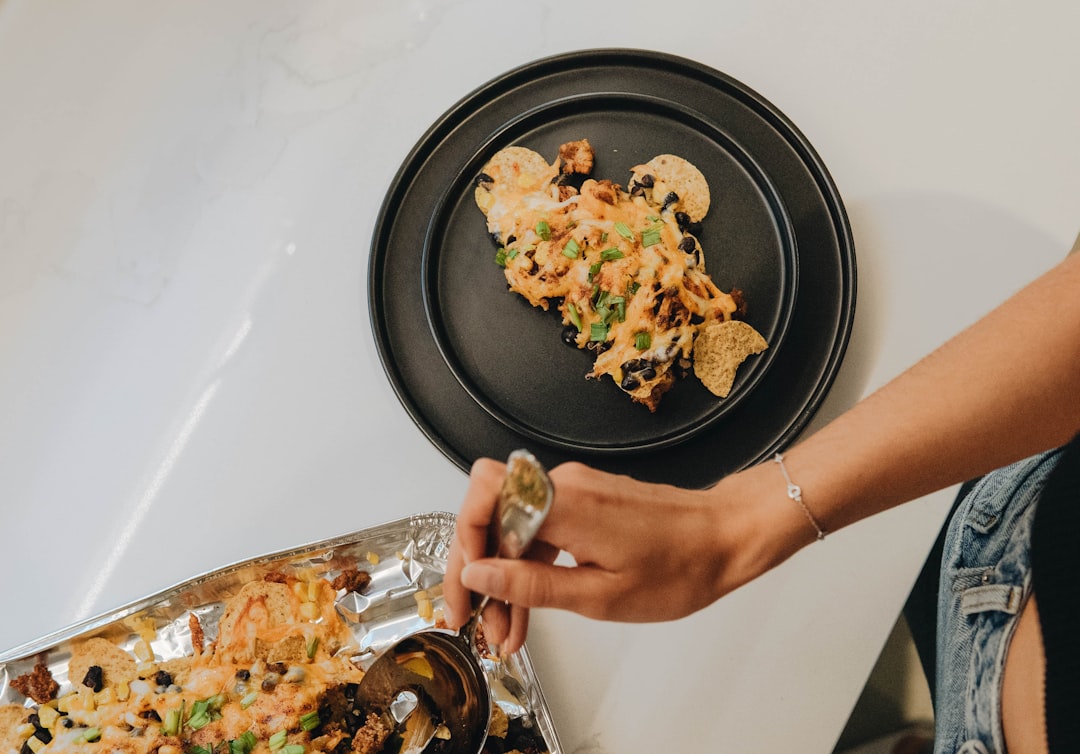 person holding black round plate with food