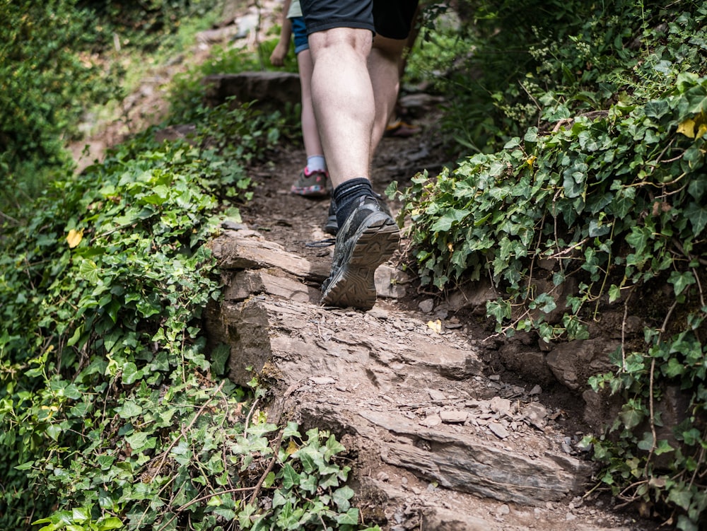 person in black hiking shoes standing on brown rock