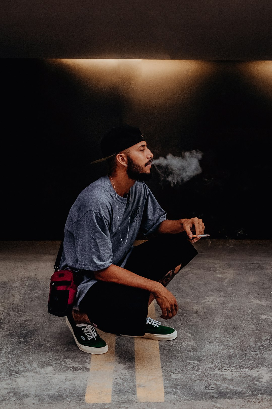 man in gray crew neck t-shirt sitting on black and red chair