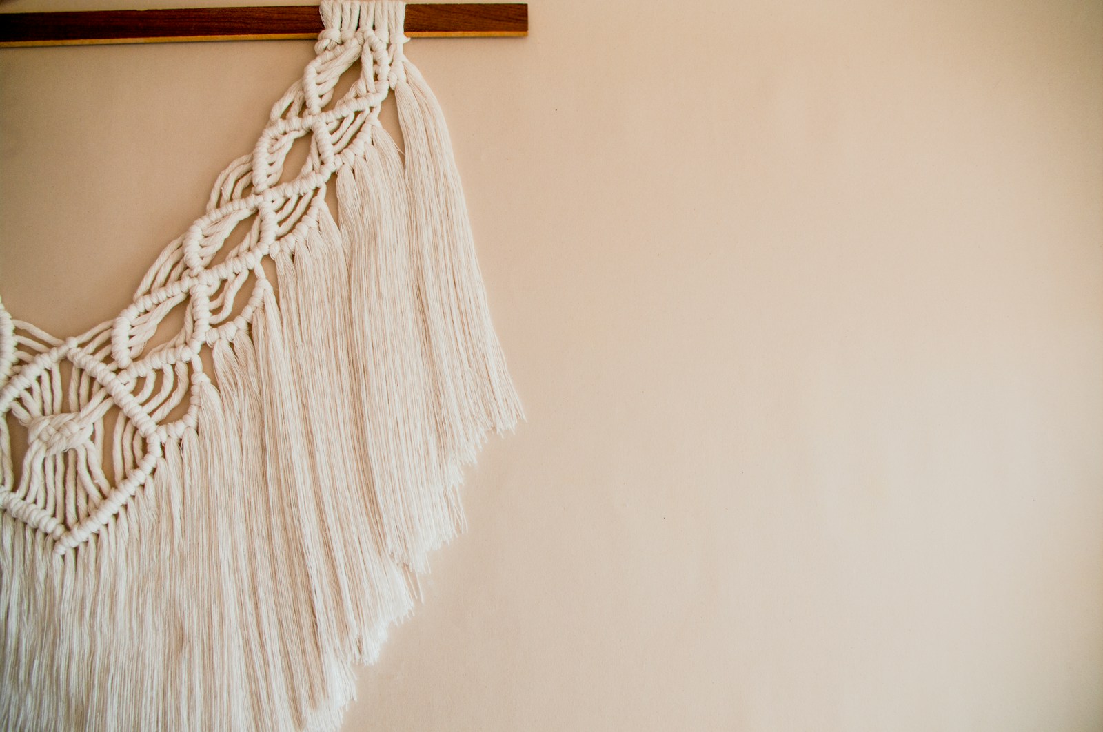 large macrame wall hanging on neutral wall