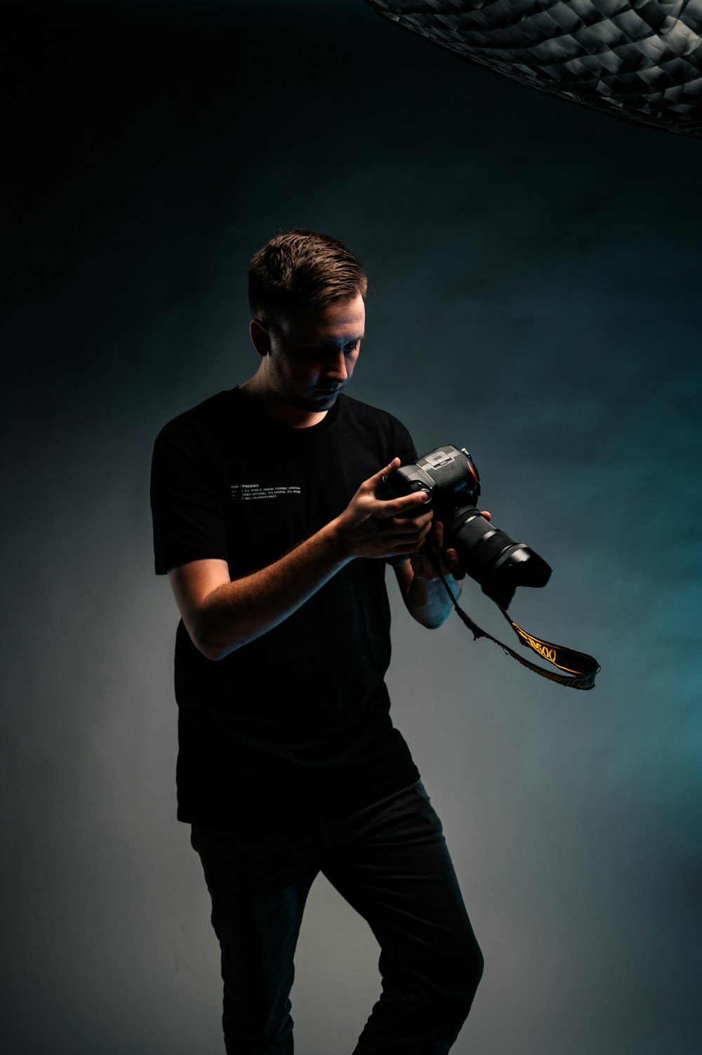 man in black crew neck t-shirt holding black dslr camera