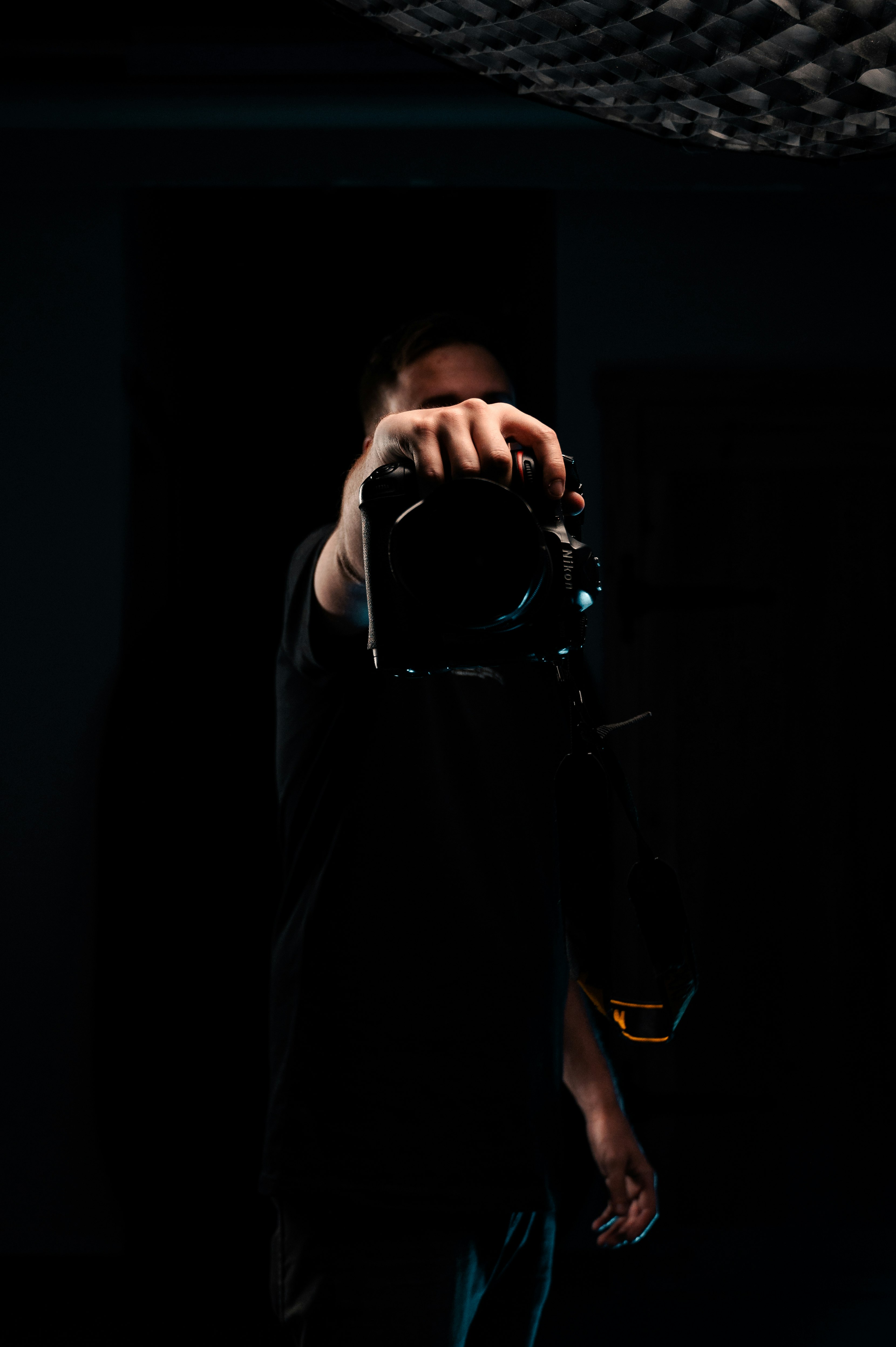 man in black hoodie holding black dslr camera