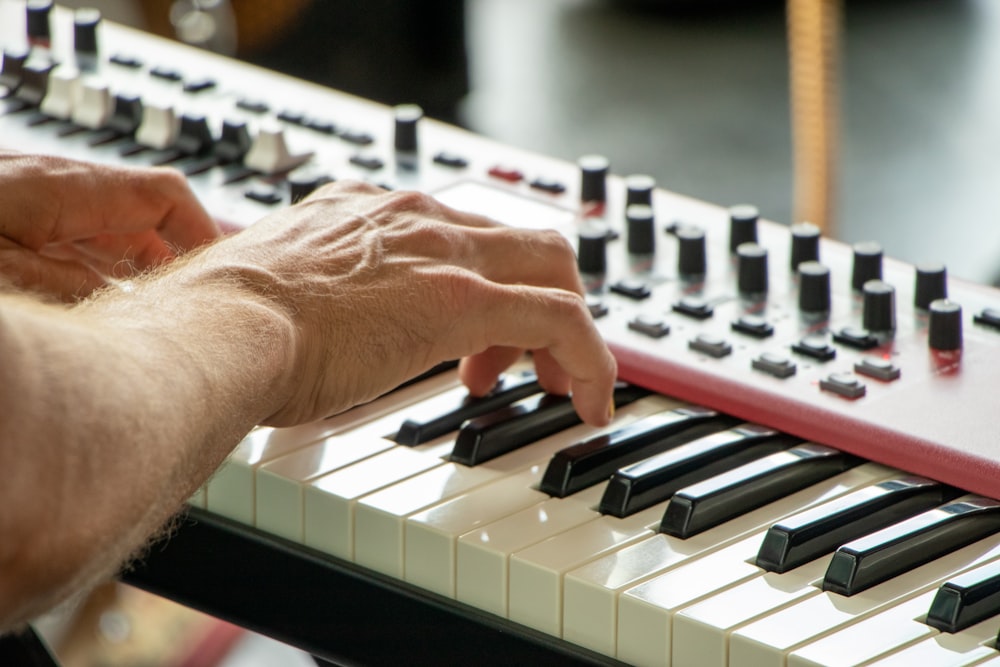 person playing white and black electric keyboard