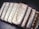 A collection of silver bars from Wall Street Mint, each bar displaying detailed engravings, including the name, weight, and purity of the silver. The bars are arranged in a slight diagonal line and feature a reflective, polished surface.