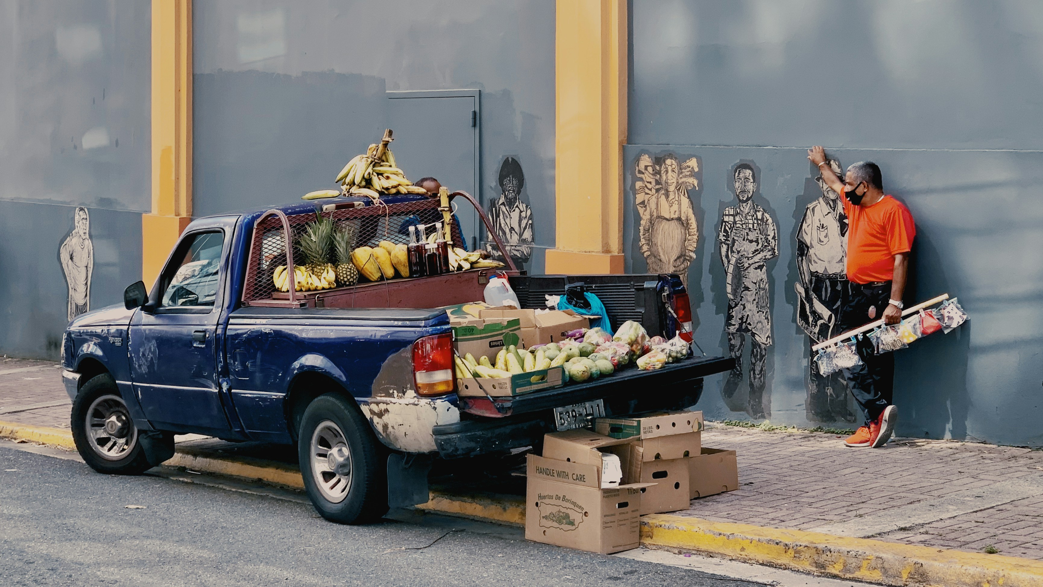 Santurce San Juan Puerto Rico street curbside fruit truck and mask selling with mural wall 2020