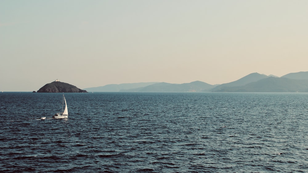 body of water near mountain during daytime