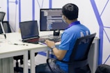 boy in blue t-shirt sitting on black office rolling chair in front of computer