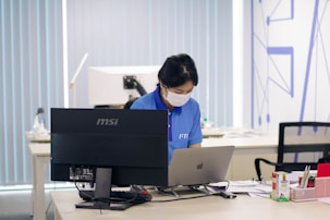 man in blue polo shirt using computer
