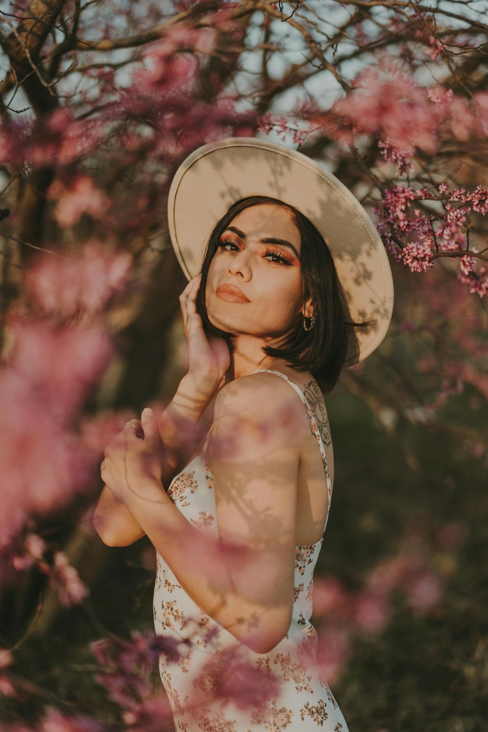 woman in white and black floral tank top and brown hat