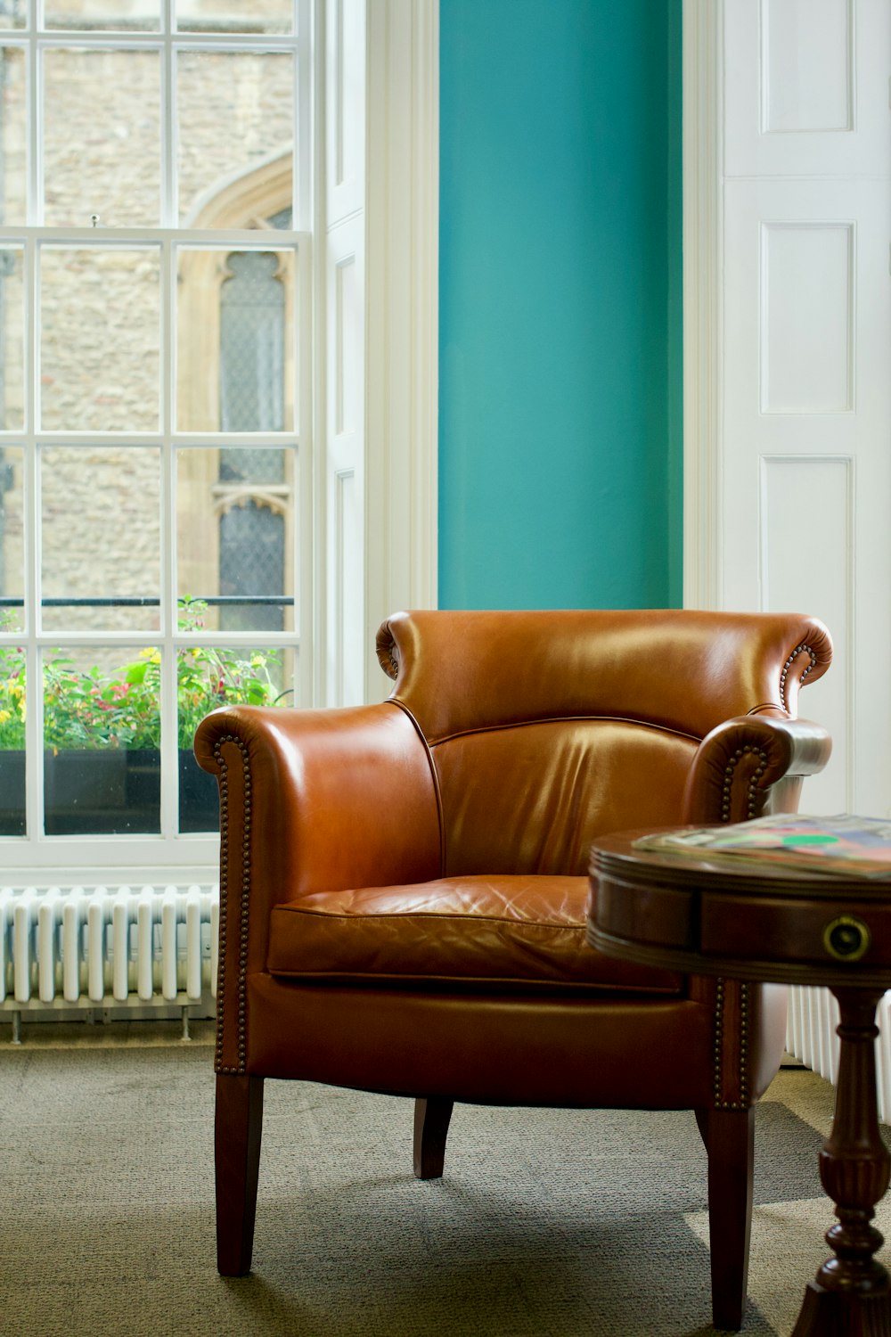 brown leather armchair beside brown wooden table