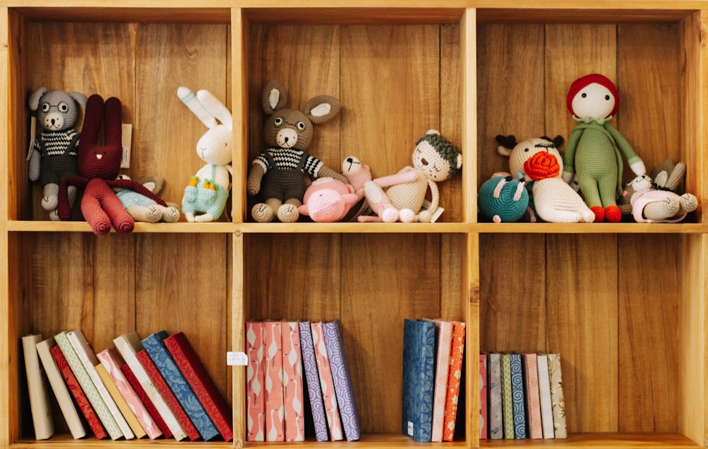 assorted animal plush toys on brown wooden shelf