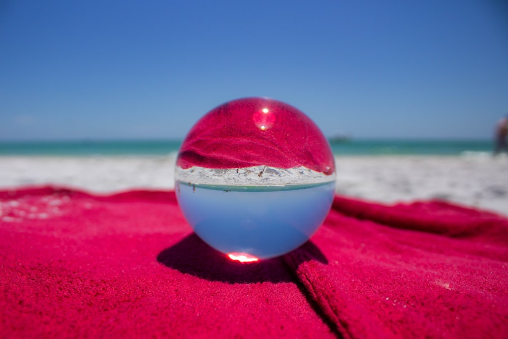 clear glass ball on red sand