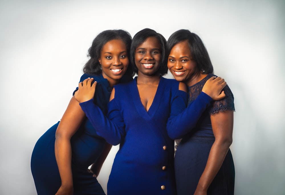 3 women in blue button up shirts smiling