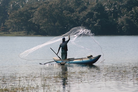 man in black long sleeve shirt riding on blue kayak on lake during daytime