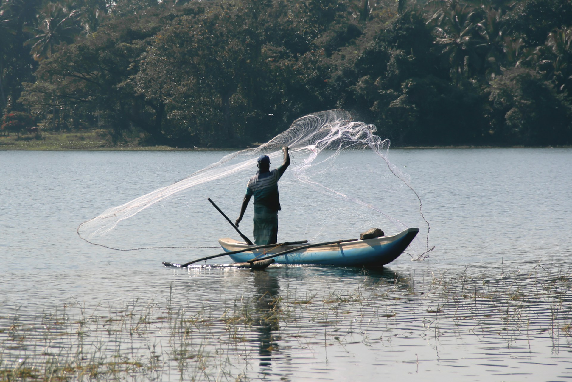 man in black long sleeve shirt riding on blue kayak on lake during daytime