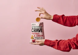 person holding white and red plastic pack