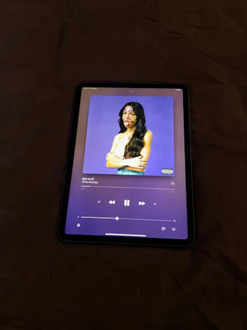 Close-up of hands browsing digital music tracks on a tablet screen.