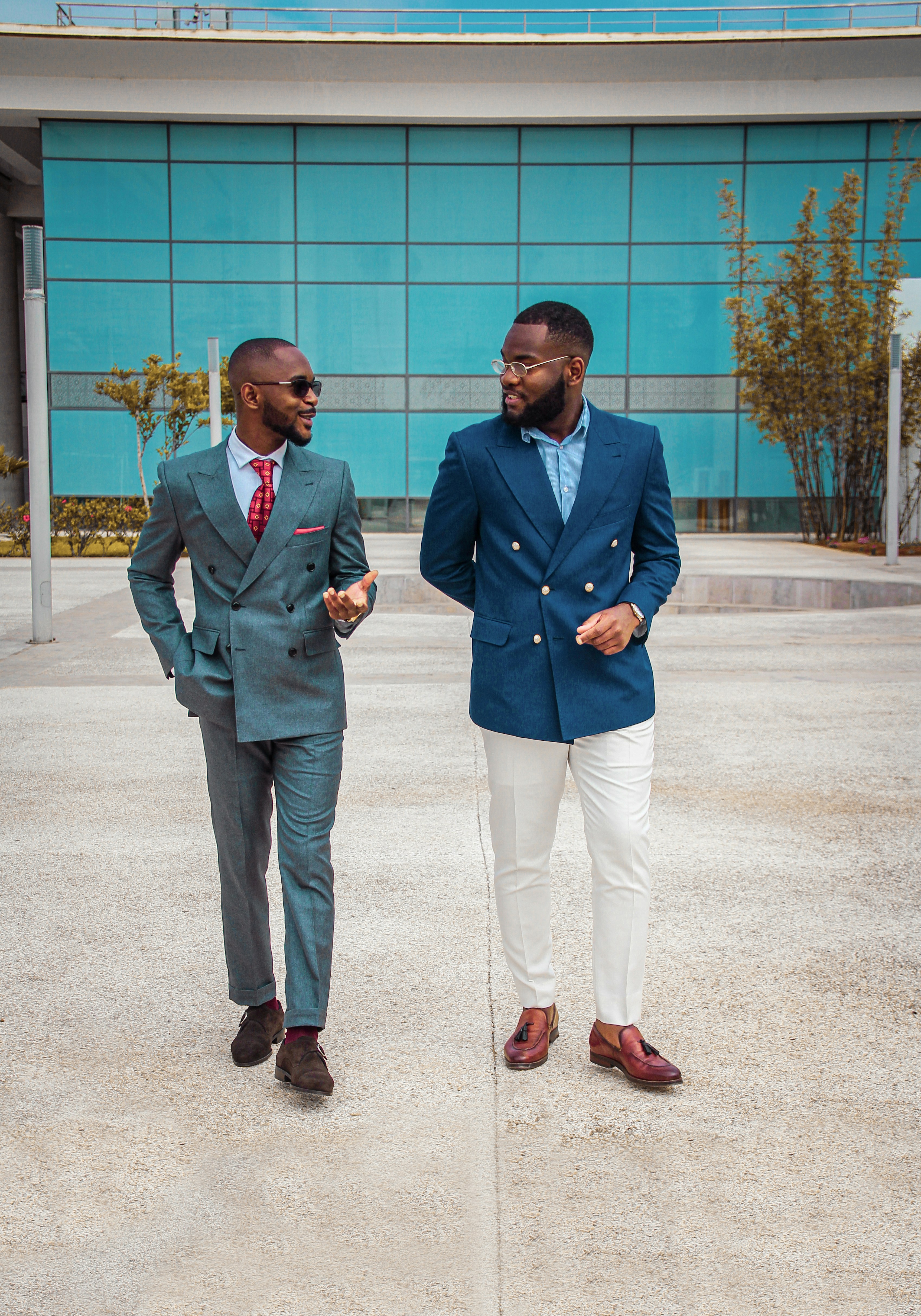 man in blue suit standing beside man in gray suitby Khalid Boutchich