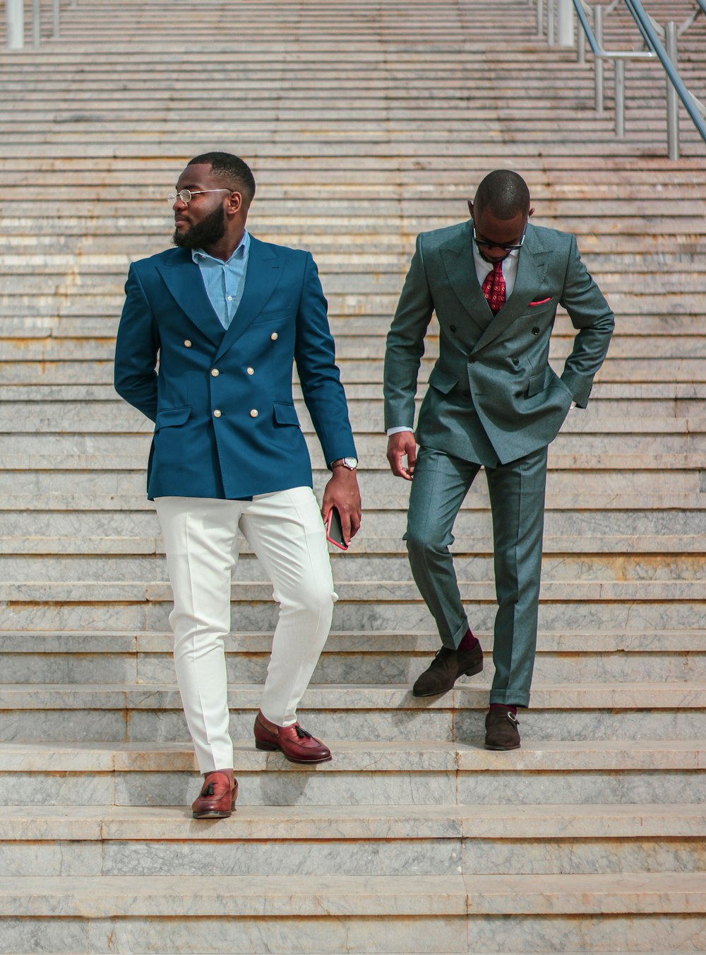 man in blue coat and white pants standing beside man in green coat