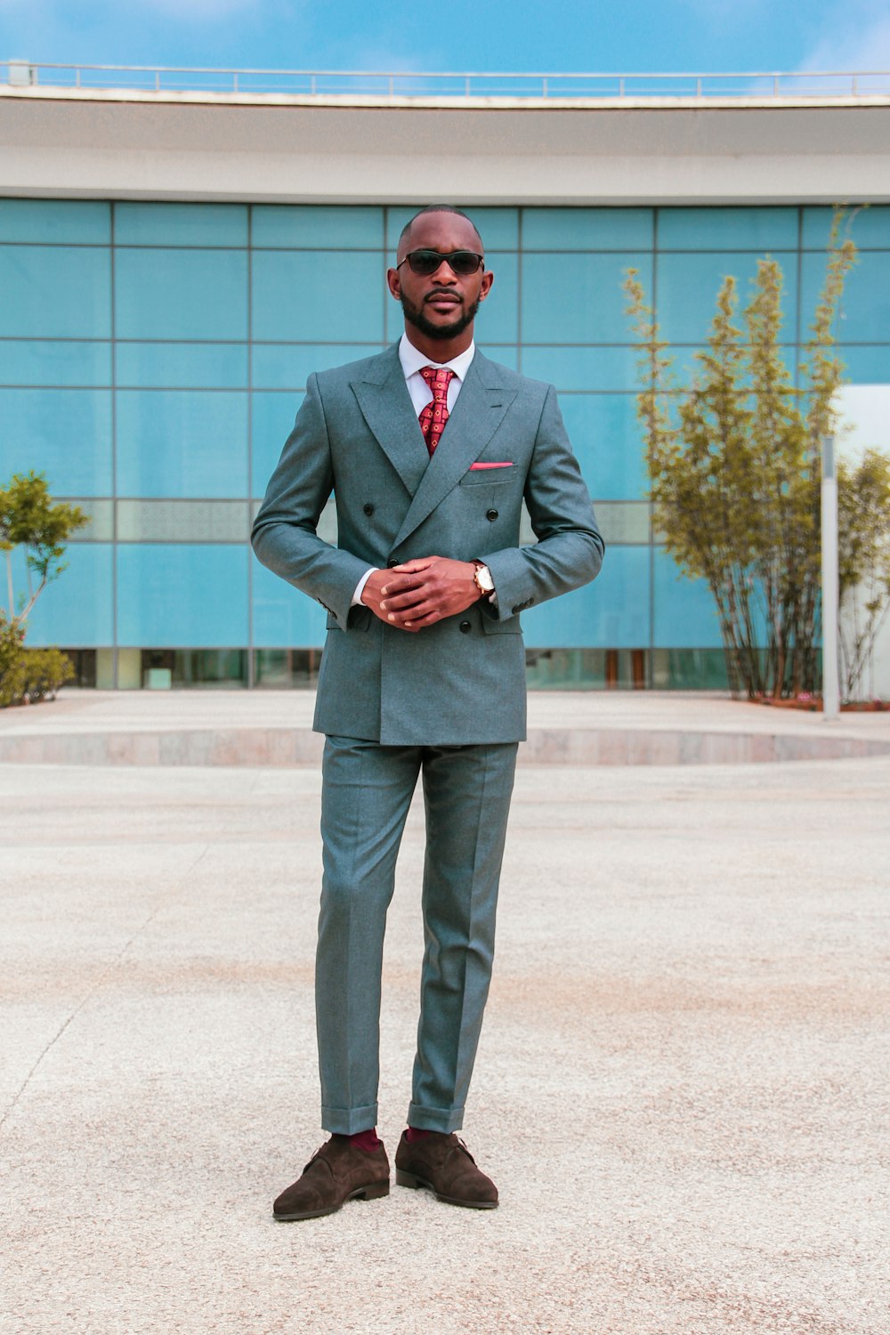 man in gray suit standing near building during daytime