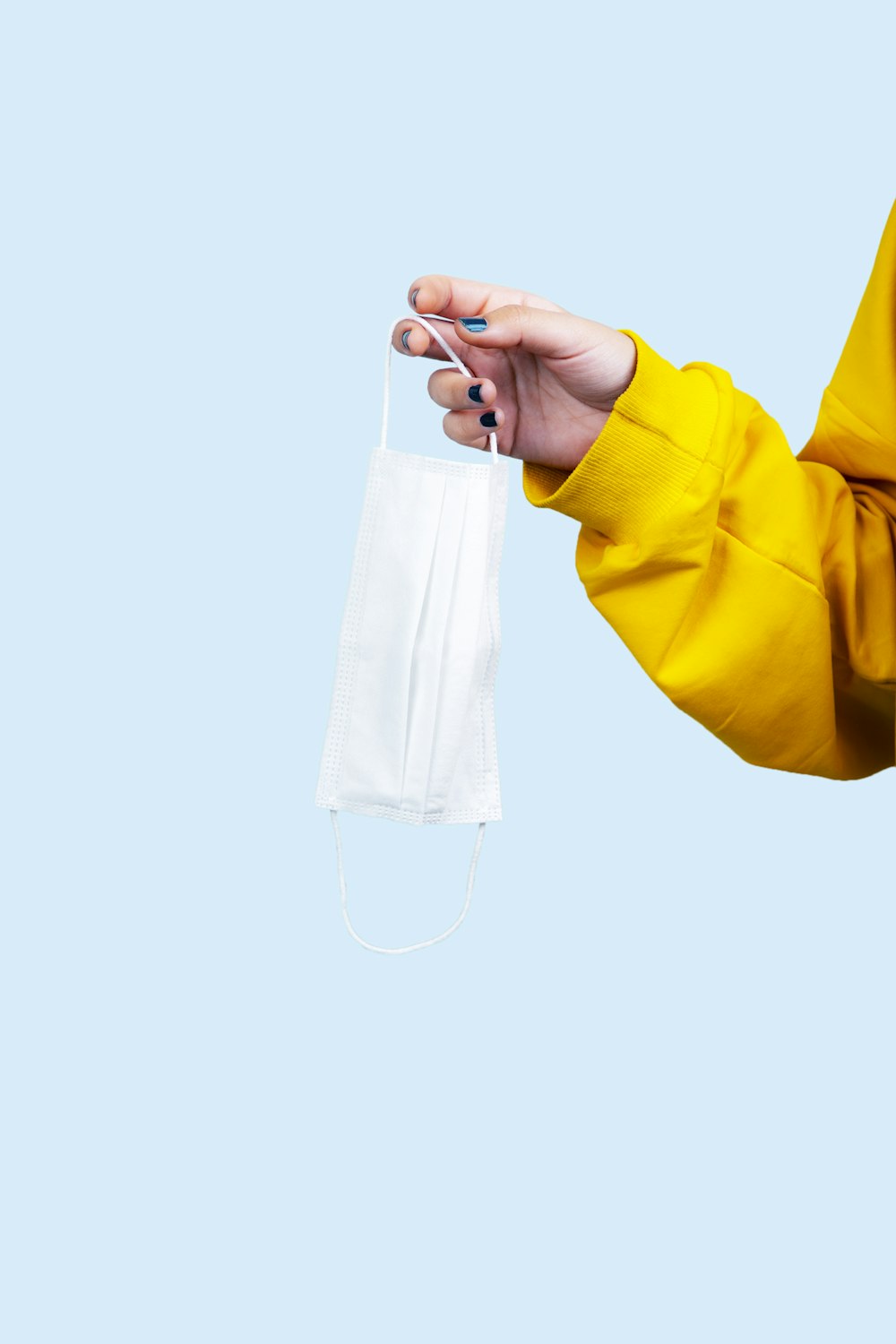 person in yellow long sleeve shirt holding clear glass bottle