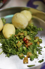Close-up of a steaming hot vada pav with chutneys on a rustic plate.
