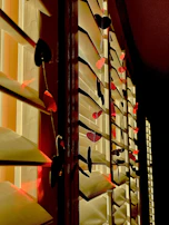 A sunlit windowsill displaying a row of small, cheerful ceramic hearts in various bright glazes.