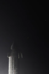 A sleek satellite launching into the starry night sky.