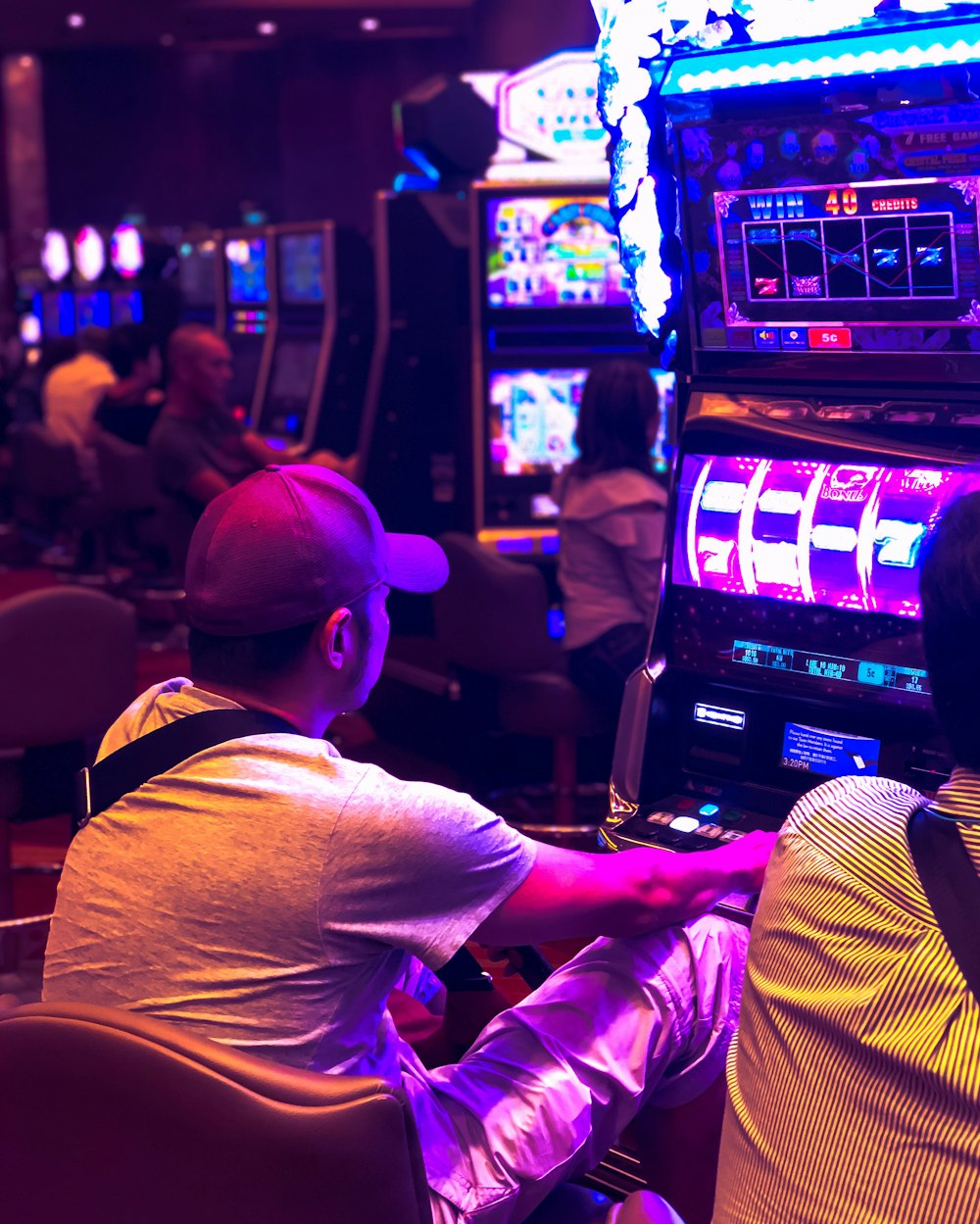 man in white t-shirt playing arcade game