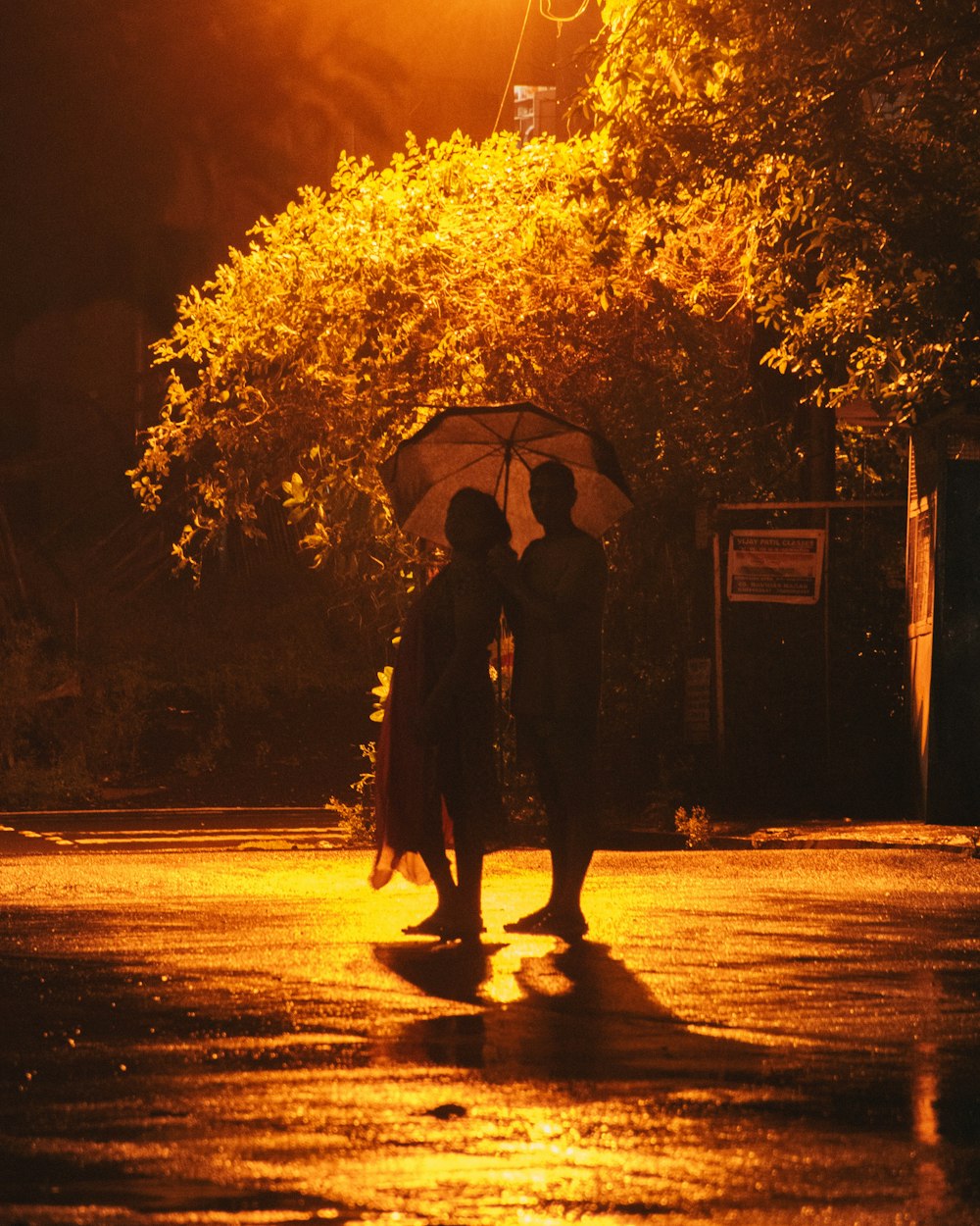 person holding umbrella walking on street during night time