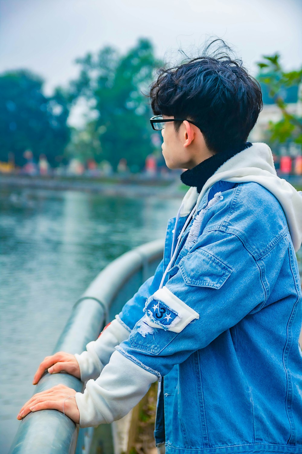 boy in blue denim jacket wearing black sunglasses sitting on white boat during daytime