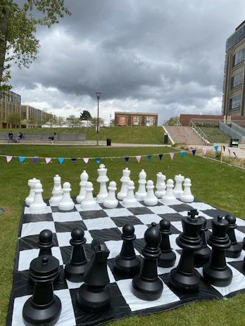 Giant Connect 4 set up on a grassy lawn, surrounded by excited players ready to make their moves