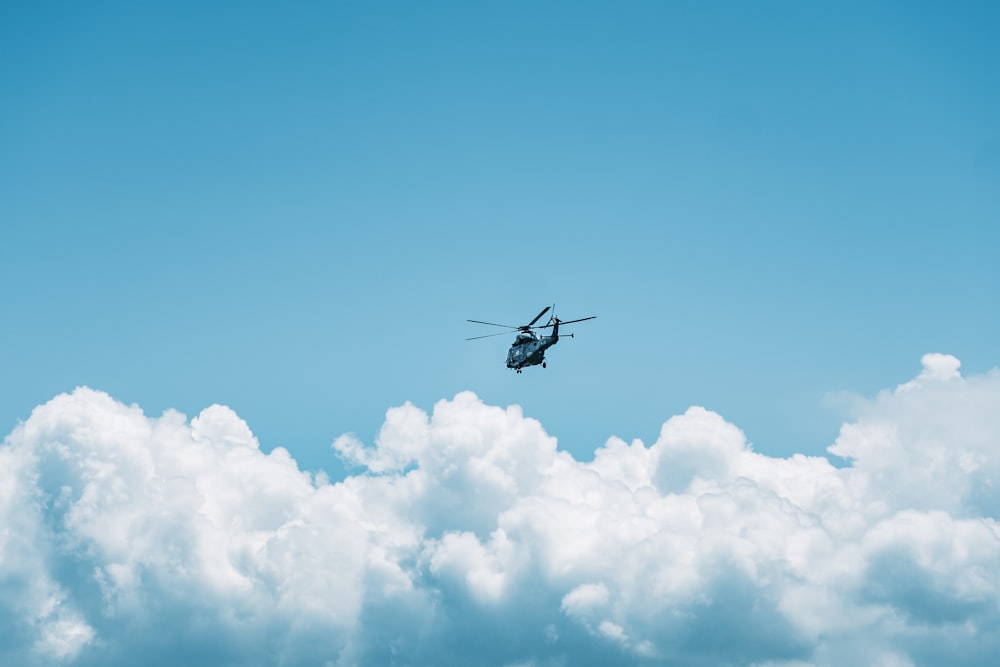 black helicopter flying in the sky during daytime