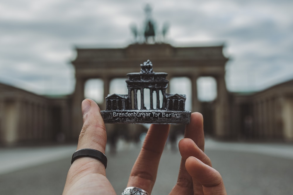 person holding black and white miniature building