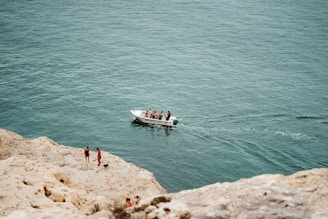A group of friends laughing on a boat cruising along the turquoise coast near Tropea.